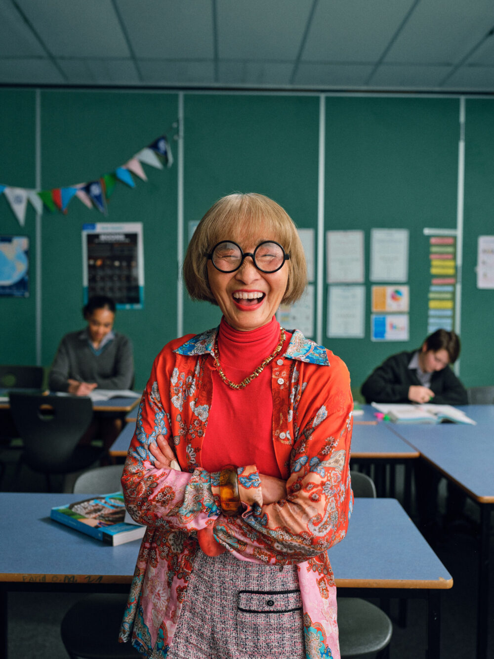 An image of a teacher smiling in a classroom