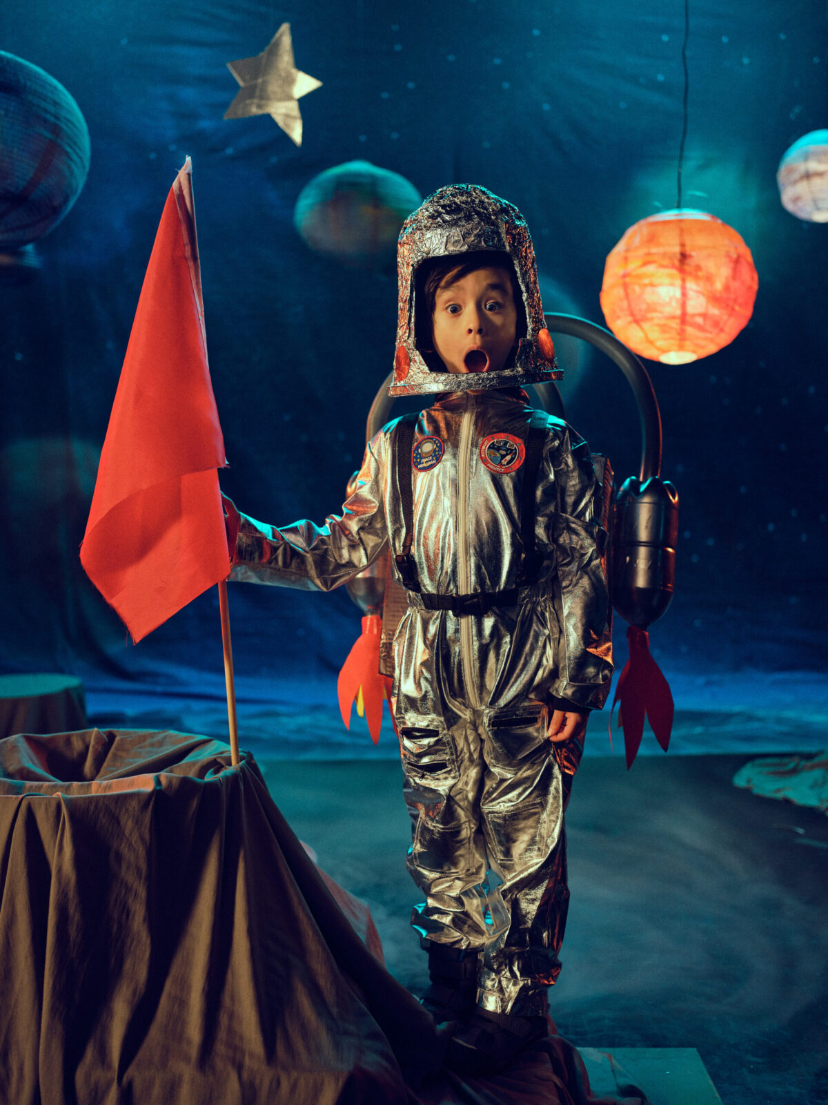 An image of a child dressed up in an astronaut costume on stage